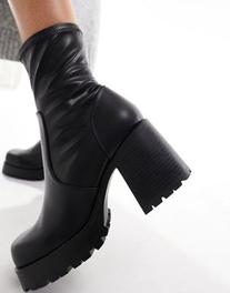 Oferta de ASOS DESIGN Retreat mid-heeled sock boots in black por $24 en asos