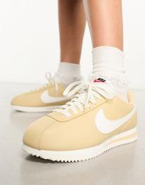 Oferta de Nike Cortez leather trainers in beige and off white por $53,97 en asos