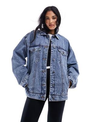 Oferta de ASOS DESIGN oversize 90's denim jacket in midwash blue por $40 en asos